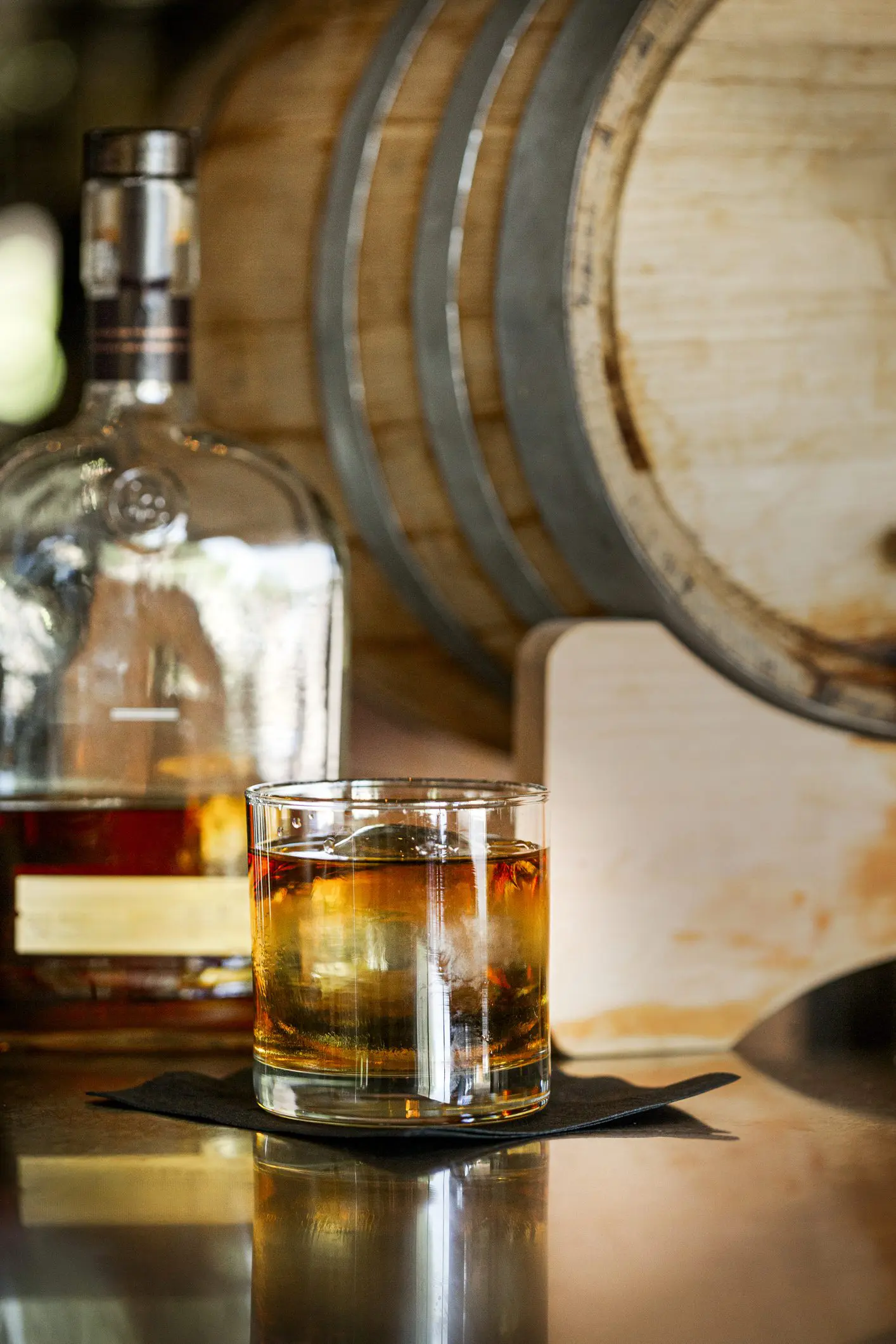 Glass of whiskey with bottle and barrel