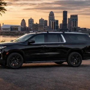 Black SUV parked at riverfront city skyline
