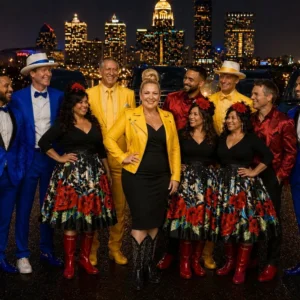 Colorful musical group posing with city skyline